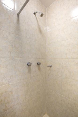 a bathroom with a shower with beige tiles at Hotel Villa Hermosa in Oaxaca City