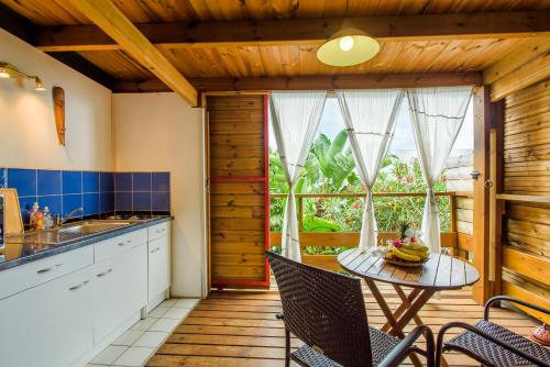 a kitchen with a table and chairs and a window at Ré Océan in Saint-Leu
