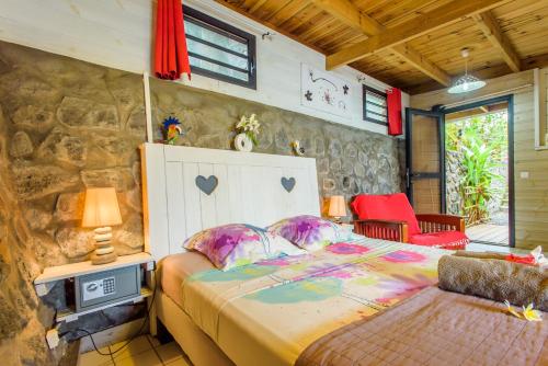 a bedroom with a bed and a stone wall at Ré Océan in Saint-Leu