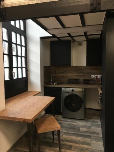 een keuken met een tafel en een wasmachine bij LOFT 8 in Douai