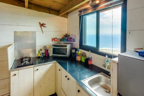 a kitchen with a stove and a sink and a window at Ré Océan in Saint-Leu