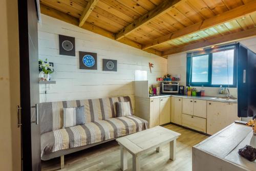 a living room with a couch and a kitchen at Ré Océan in Saint-Leu