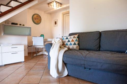 a living room with a blue couch and a table at DomoMea - Villetta Poseidone in Costa Rei