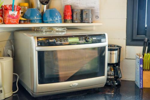 a microwave oven sitting on top of a kitchen counter at Ré Océan in Saint-Leu