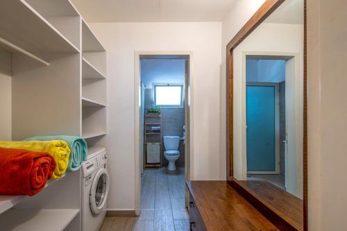a laundry room with a washing machine and a mirror at רז אירוח ברמה in Qasrîne