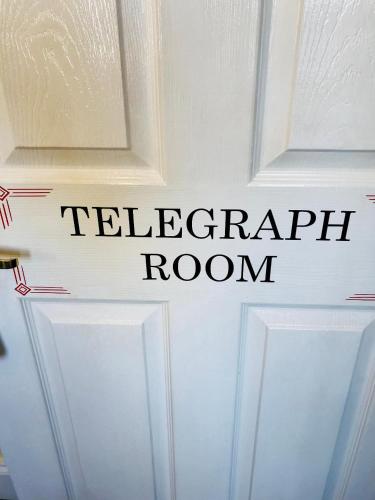 a sign on a white door that reads telephone room at The Old Post Office Boutique Guesthouse in Hythe