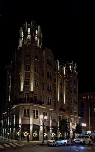 a large building at night with cars parked in front at ALBOR II in Gijón