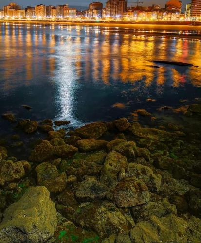 a large body of water with a city in the background at ALBOR II in Gijón