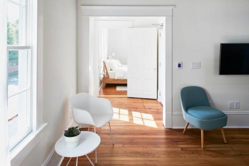 a living room with two chairs and a table at Guest House Raleigh- Adults Only in Raleigh