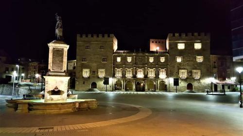 a large building with a statue in front of it at night at ALBOR II in Gijón