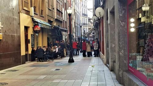a group of people walking down a city street at ALBOR II in Gijón