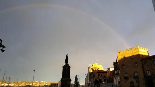 a statue in the middle of a city with buildings at ALBOR II in Gijón