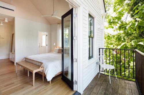 1 dormitorio con 1 cama y un banco en el balcón en Guest House Raleigh en Raleigh