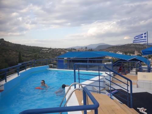 a woman in a swimming pool on a cruise ship at Heliotopos Apartments in Tolo