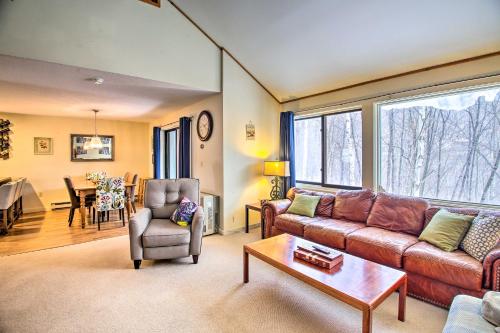 a living room with a couch and a table at Loon Mountain Condo with Pool and Game Room Access! in Lincoln