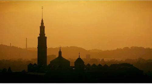 a silhouette of a city at sunset with a clock tower at ALBOR II in Gijón