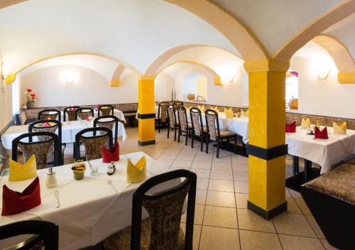 a restaurant with tables and chairs in a room at Hotel & Ferienwohnungen Bohlenblick in Saalfeld