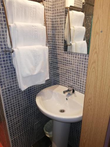a bathroom with a white sink and towels at ALBOR II in Gijón