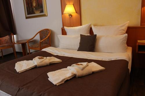 ein Hotelzimmer mit einem Bett mit Handtüchern darauf in der Unterkunft Hotel Pirsch in Ramstein-Miesenbach