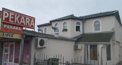 a white building with a sign on the side of it at Lovely Private Flats FREE parking in Novi Sad