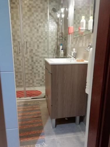 a bathroom with a sink and a shower at Sailorman House in Aveiro
