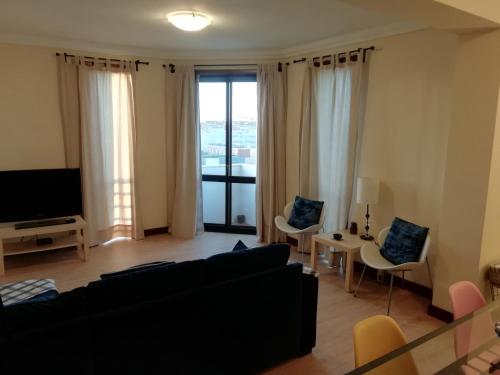 a living room with a couch and a tv at Sailorman House in Aveiro
