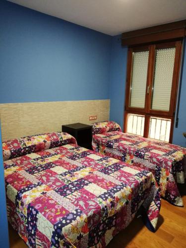 a bedroom with two beds and a quilt at ALBOR II in Gijón