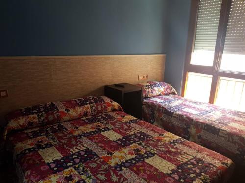 a bedroom with two beds and a quilt on the bed at ALBOR II in Gijón