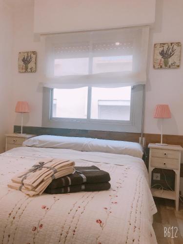 a bedroom with a bed with two night stands and a window at Apartamento Calipso in Salou