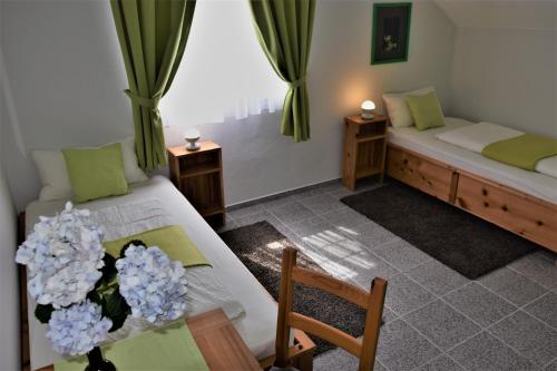 una habitación con 2 camas y una mesa con flores en Calma do Mar, en Madalena