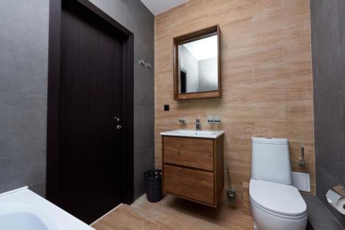a bathroom with a toilet and a sink and a mirror at Medical Hotel & SPA Tyumen in Tyumen