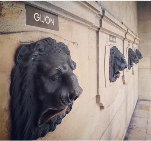 a statue of a lion on the side of a building at ALBOR II in Gijón
