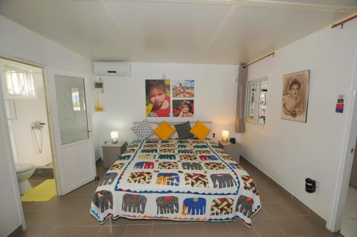 1 dormitorio con 1 cama grande y colcha colorida en Chalet Kestrel with pool on the beach, en Riambel