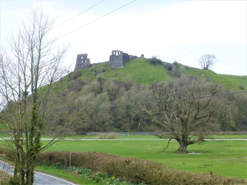 a castle on top of a hill with a green field at Gerycastell Luxury Holiday Apartment with Stunning Views & EV Station Point in Carmarthen