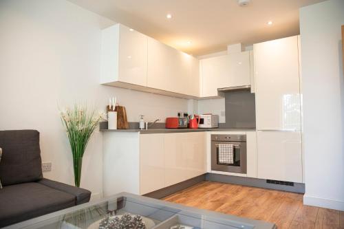 a living room with a couch and a kitchen at Sunshine Place in Enfield