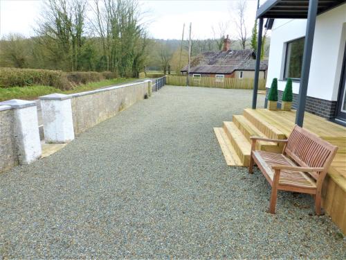 a wooden bench sitting on the side of a building at Gerycastell Luxury Holiday Apartment with Stunning Views & EV Station Point in Carmarthen
