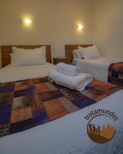 a hotel room with two beds with a quilt on them at Trotamundos in Puerto Natales
