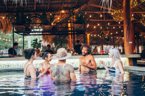 a group of people sitting in a swimming pool at the SPACE. in San Juan del Sur