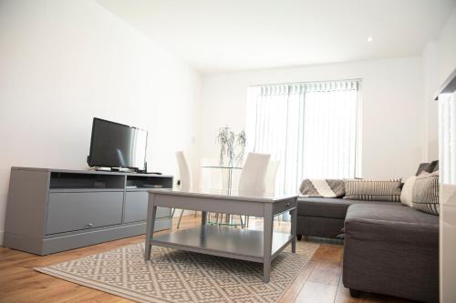 a living room with a table and a couch at Sunshine Place in Enfield
