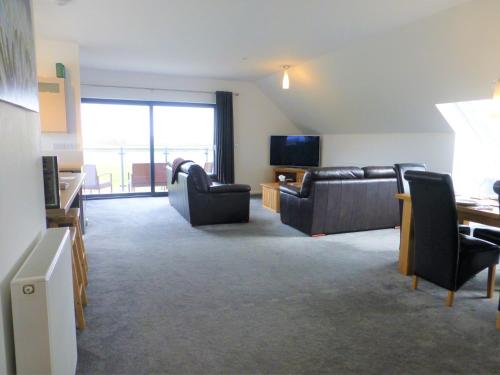 a living room with couches and a flat screen tv at Gerycastell Luxury Holiday Apartment with Stunning Views & EV Station Point in Carmarthen