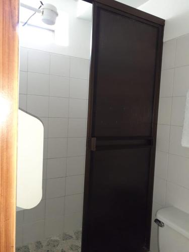 a bathroom with a toilet and a black door at Hotel Mirador Santana in Anserma