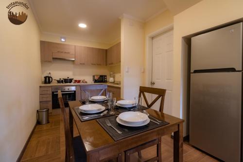 a kitchen with a wooden table with plates on it at Trotamundos in Puerto Natales