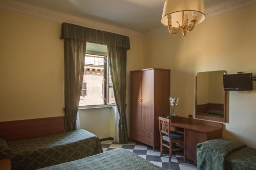 une chambre d'hôtel avec deux lits, un bureau et une fenêtre dans l'établissement Hotel Giorgina, à Rome