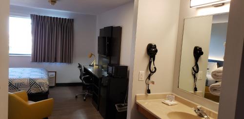 a hotel room with a bathroom with a sink and a mirror at Motel 6-Kewanee, IL in Kewanee