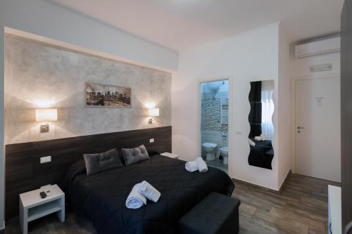 a bedroom with a black bed and a bathroom at TIBURTINA INN GUEST HOUSE in Rome