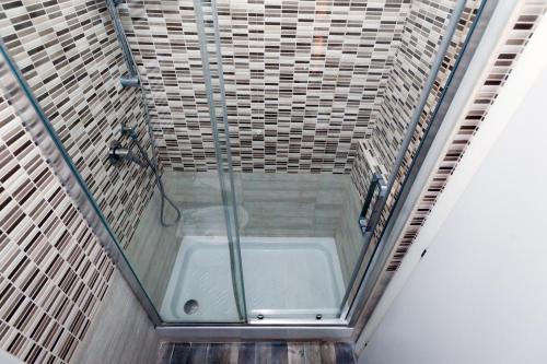 a shower with a glass door in a bathroom at TIBURTINA INN GUEST HOUSE in Rome