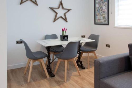 a dining room table with four chairs and a white table at Blackbird Luxury Apartments Room 5 in Blackpool