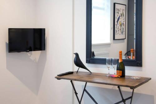 a bird sitting on a table with a bottle and glasses at Blackbird Luxury Apartments Room 5 in Blackpool