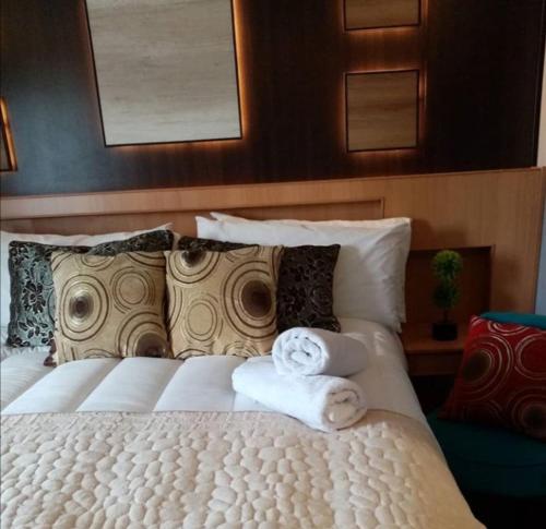 Un dormitorio con una cama blanca con toallas. en Hotel Mont Suite-Mte. Aguila en Cabrero