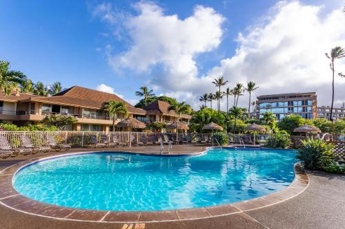 a pool at a resort with chairs and umbrellas at Aston Maui Kaanapali Villas in Lahaina